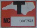 close-up of "T" sticker from the plate shown at left